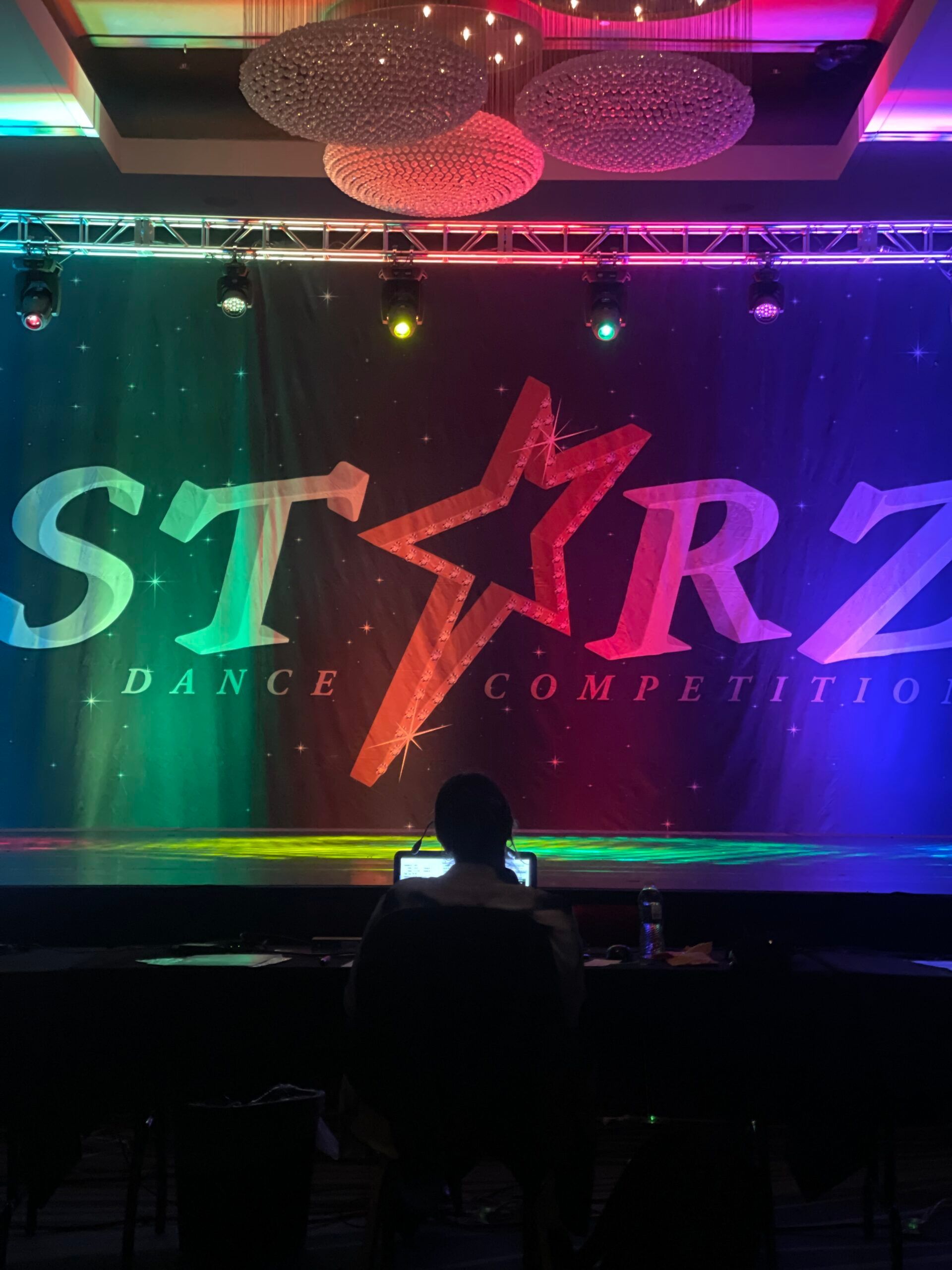 A man sits in front of a starz dance competition stage