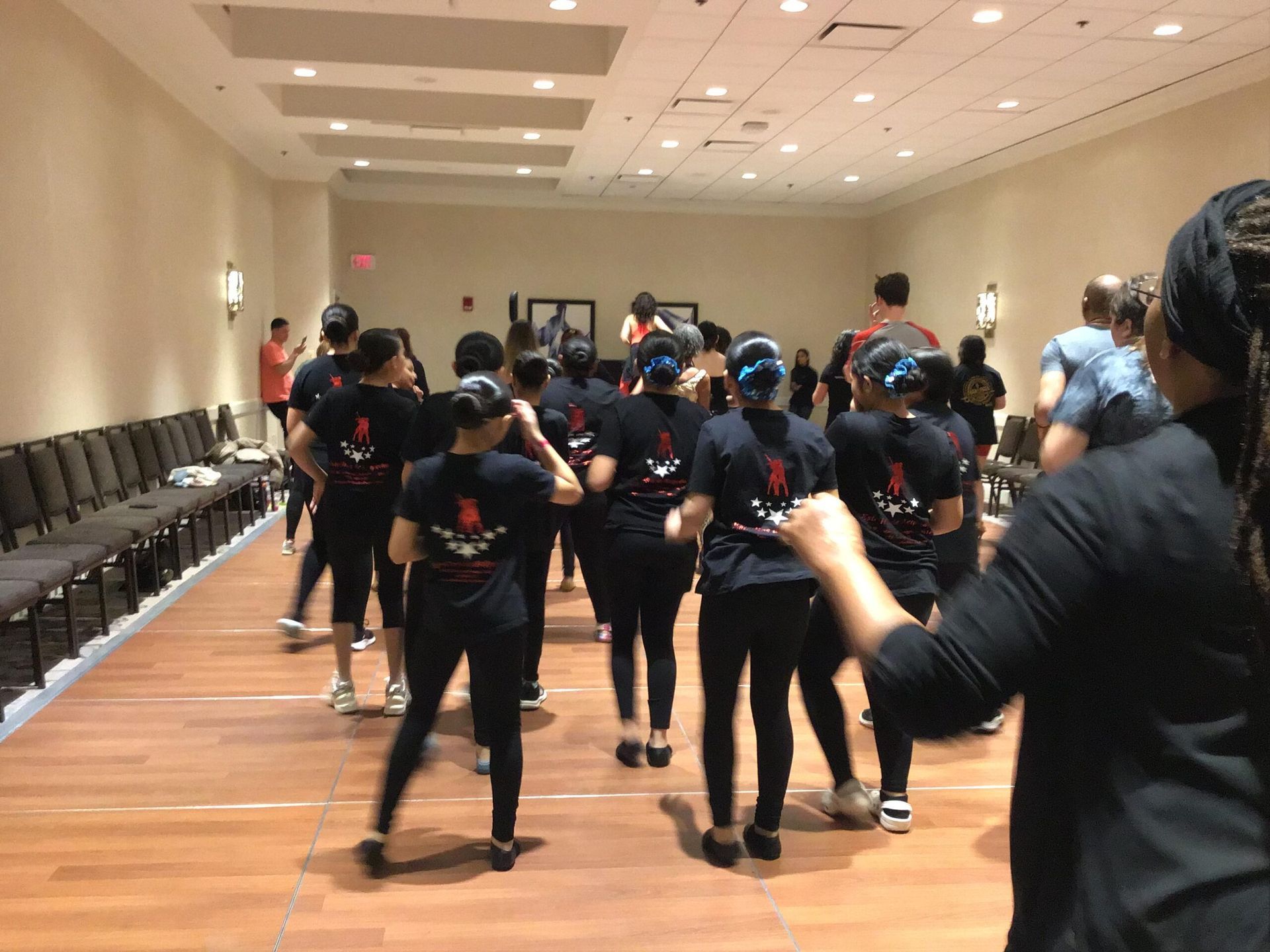 A group of people are dancing in a large room