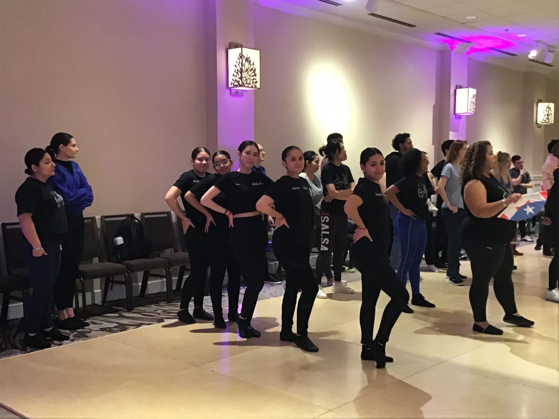 A group of people are standing in a room and dancing.