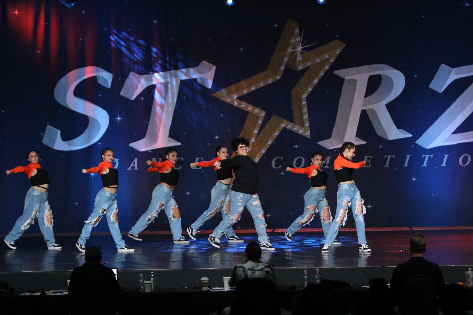 A group of people are dancing on a stage in front of a starz logo.