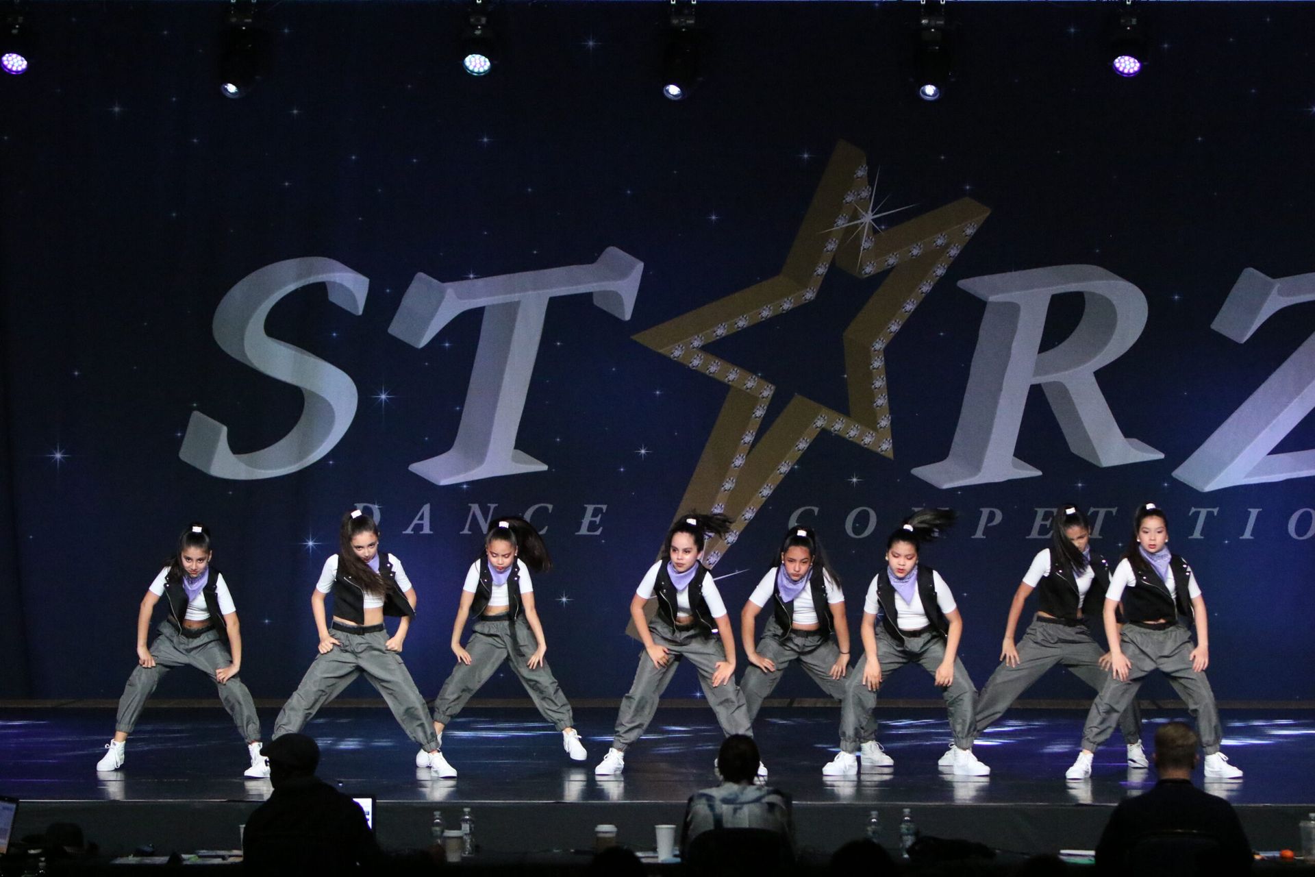 A group of young girls are performing on a stage in front of a starz logo
