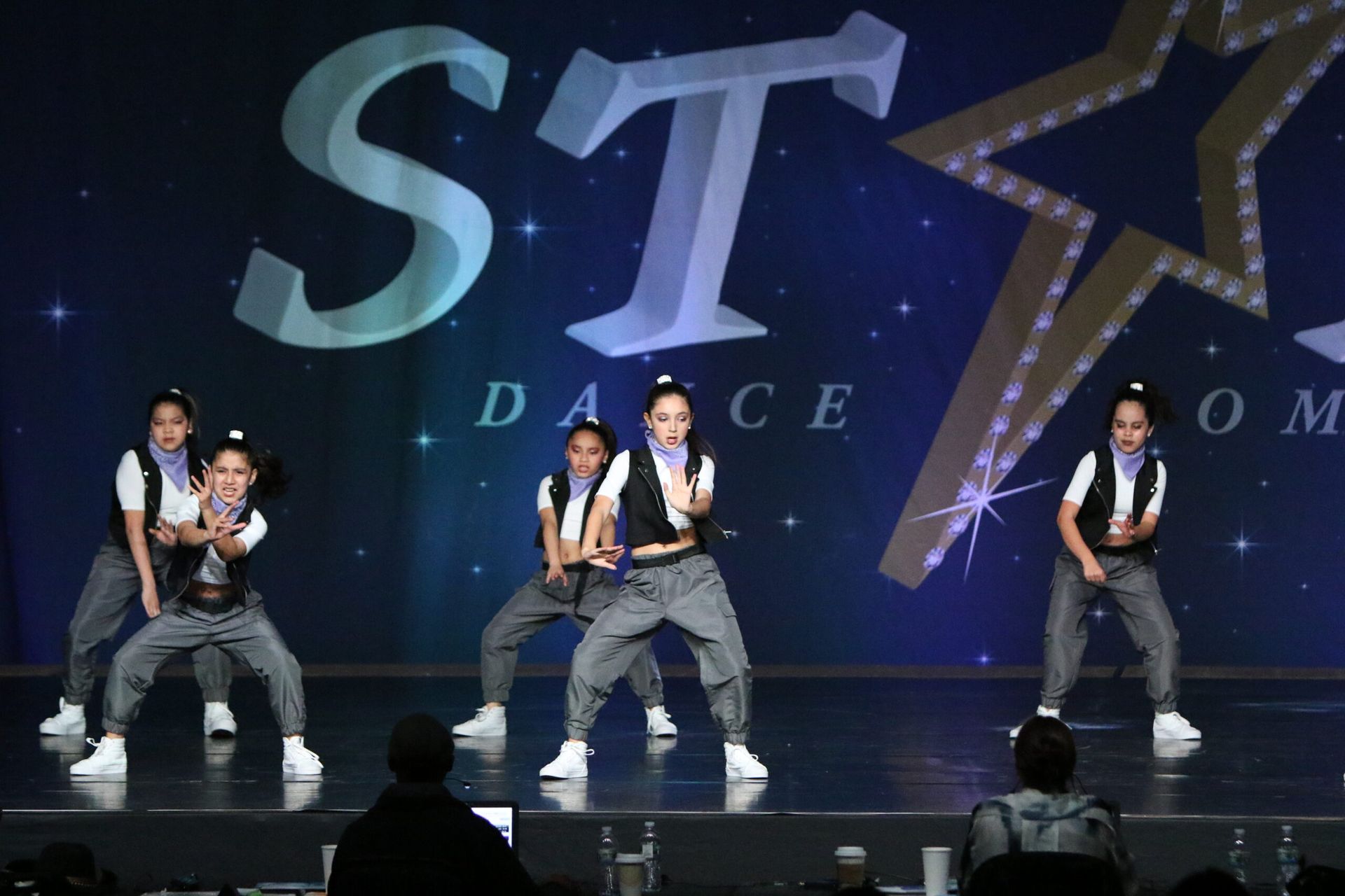 A group of young girls are dancing on a stage.