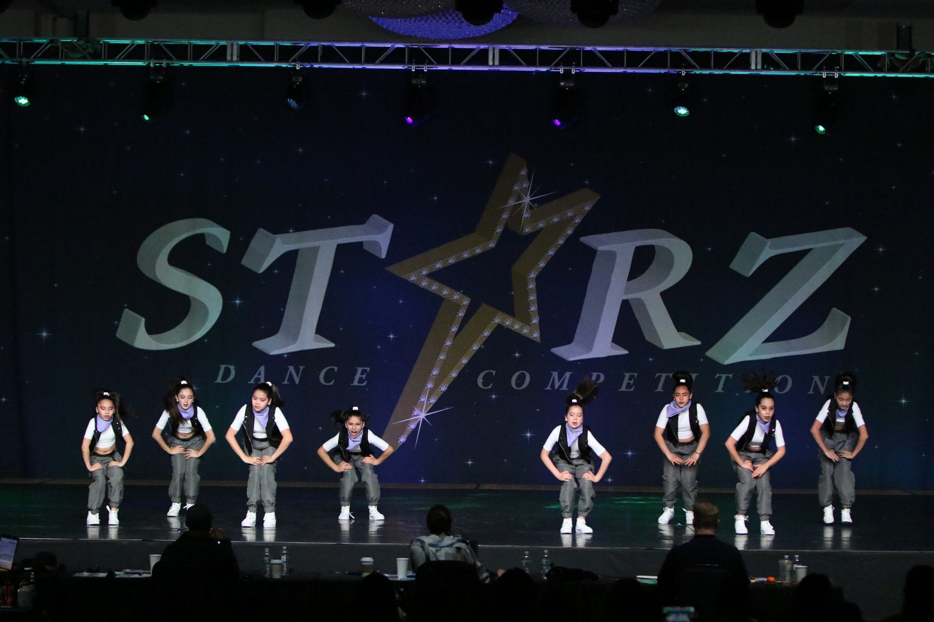 A group of dancers are performing in front of a starz dance competition sign