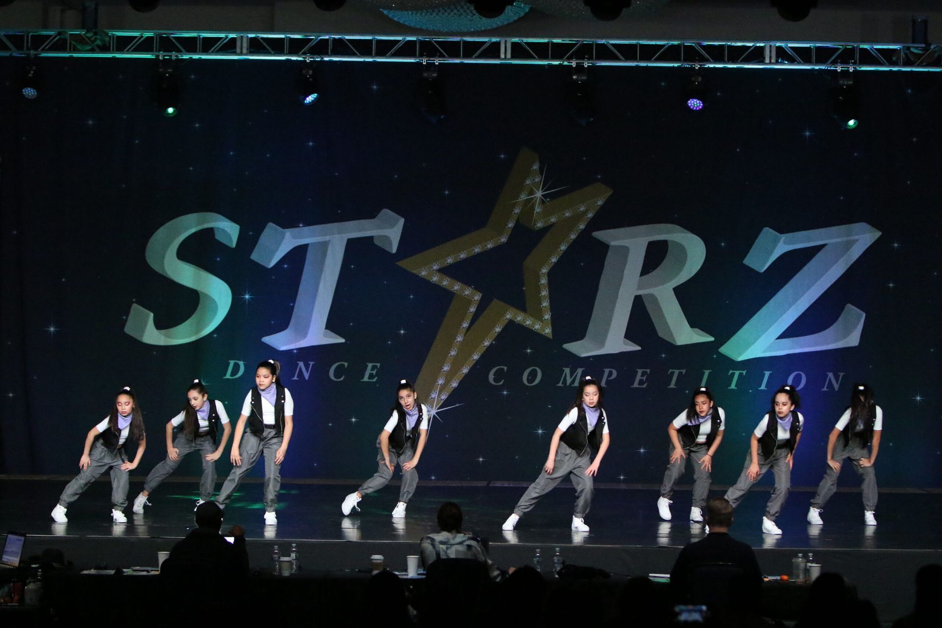 A group of people are dancing on a stage in front of a starz dance competition sign