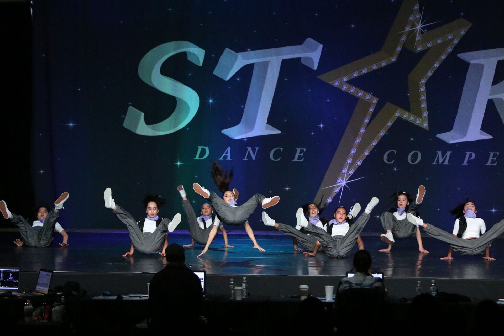 A group of dancers are performing in front of a star dance compe logo