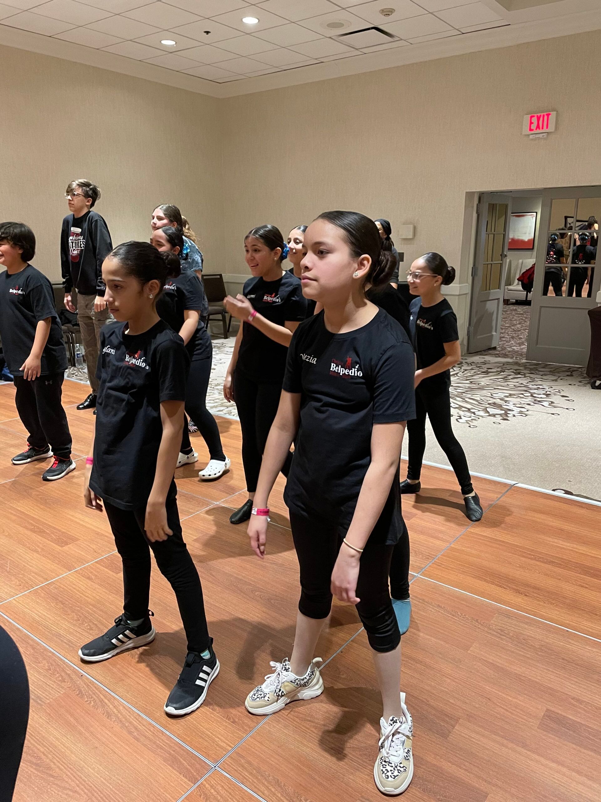 A group of young girls are standing on a dance floor.