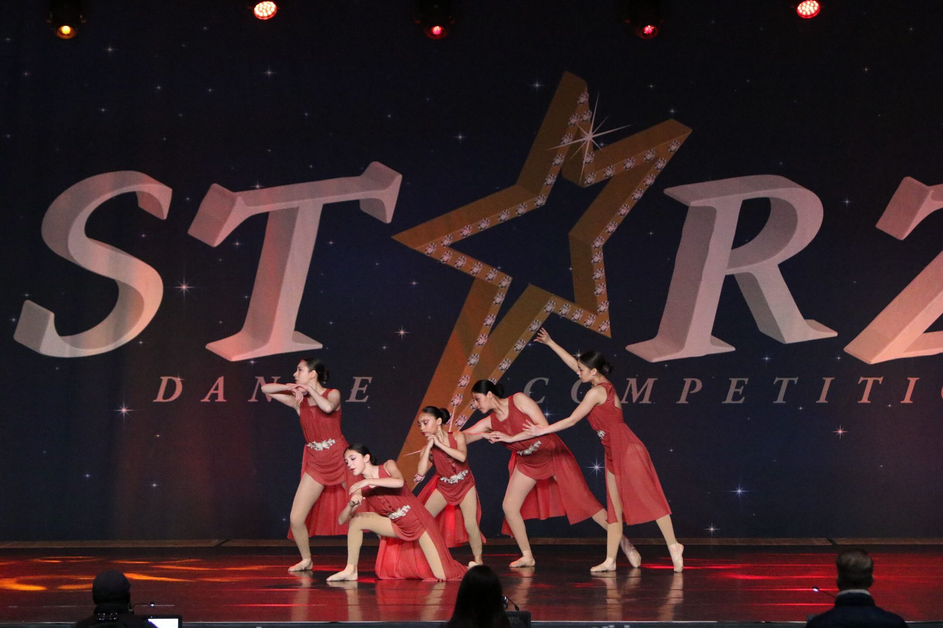 A group of women are dancing in front of a star dance competition logo
