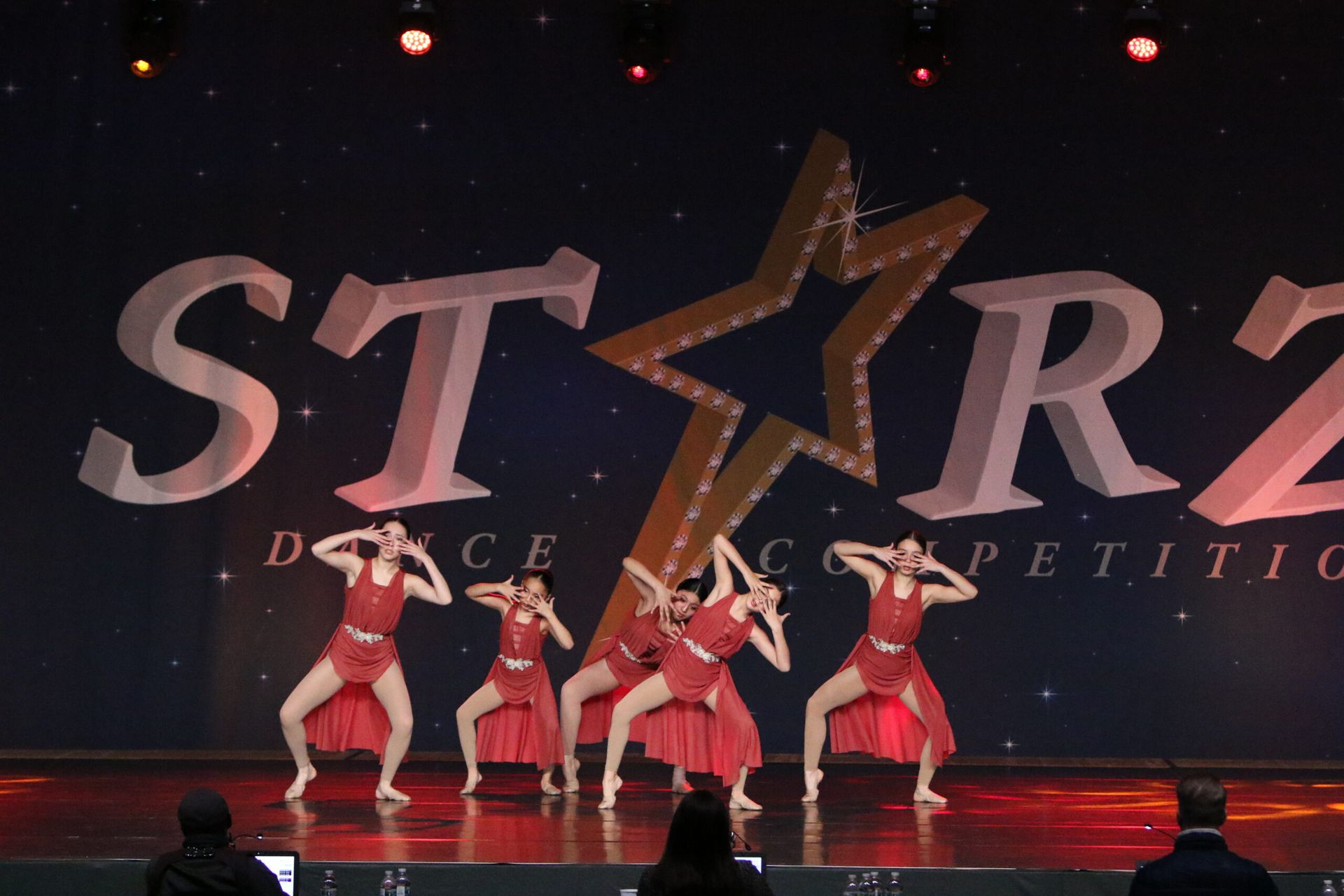 A group of dancers are performing in front of a starz logo