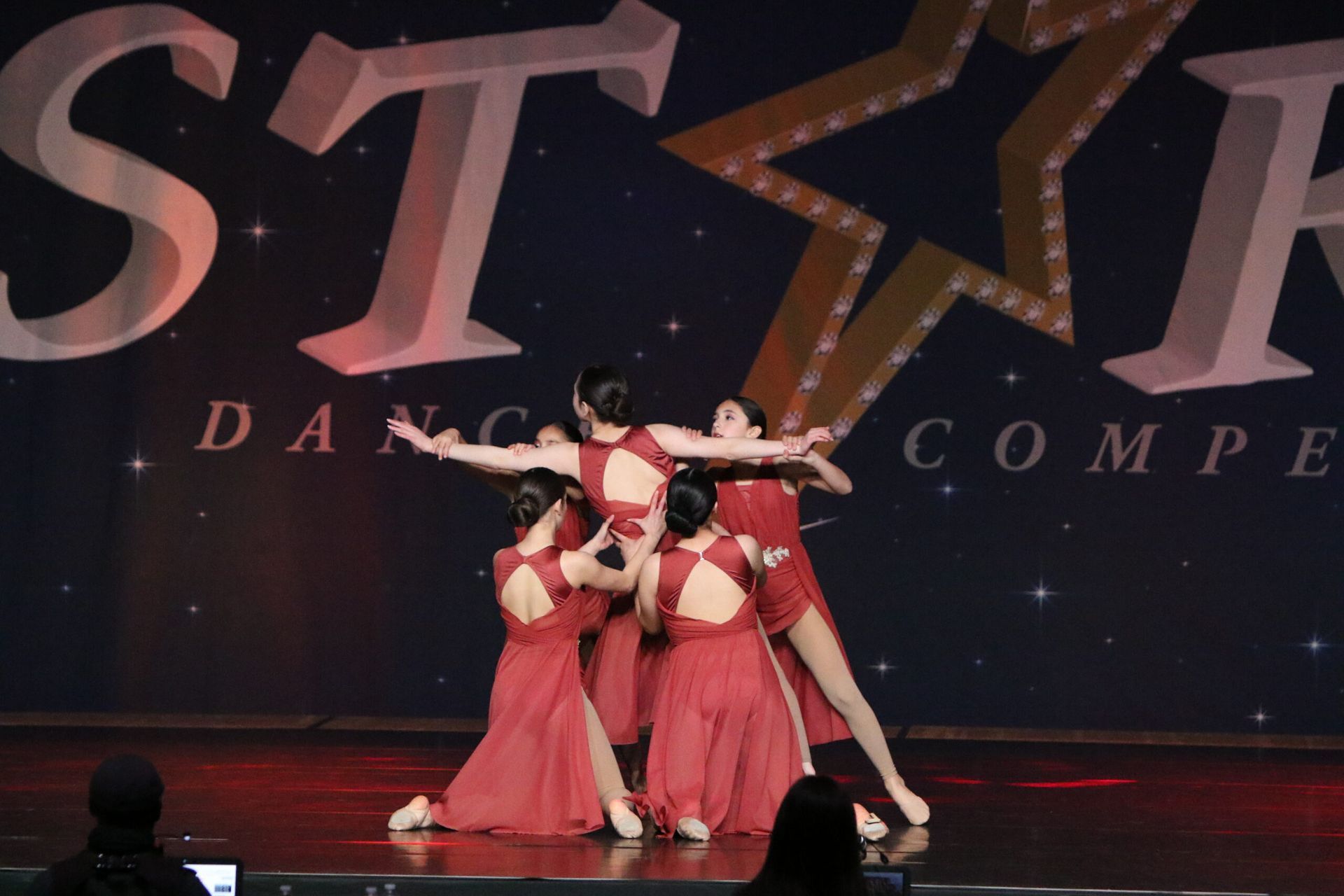 A group of dancers are performing in front of a sign that says star dance compe