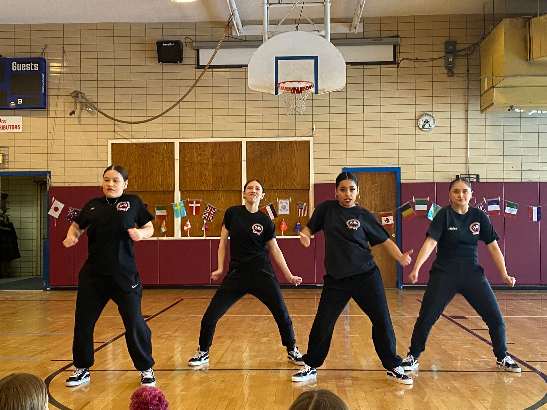A group of girls are dancing on a basketball court