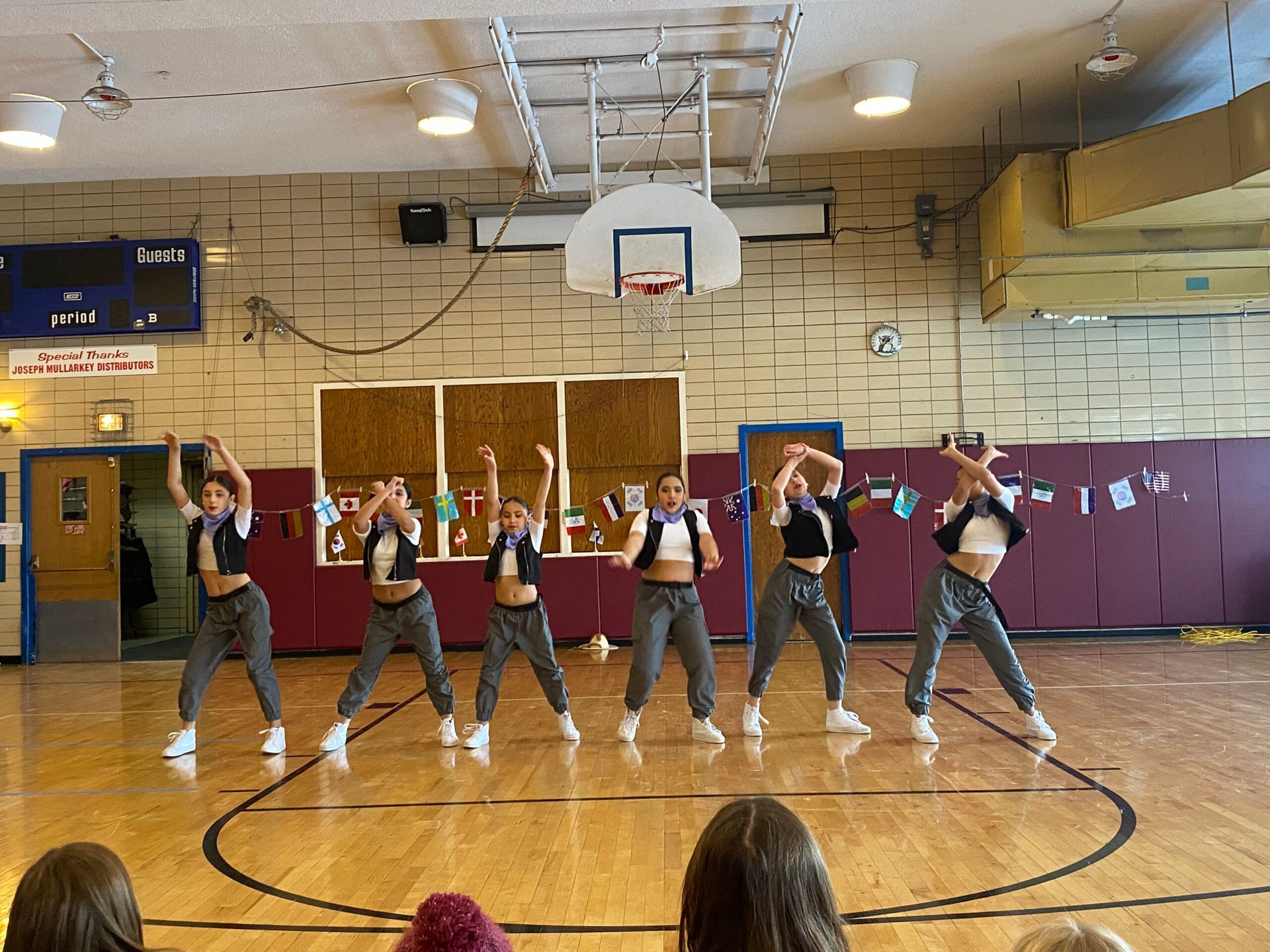 A group of young women are dancing on a basketball court.