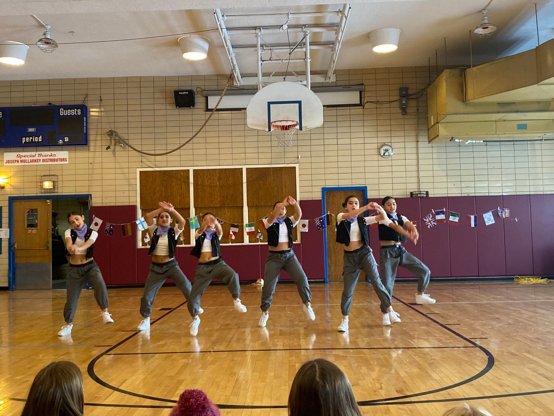 A group of people are dancing on a basketball court.