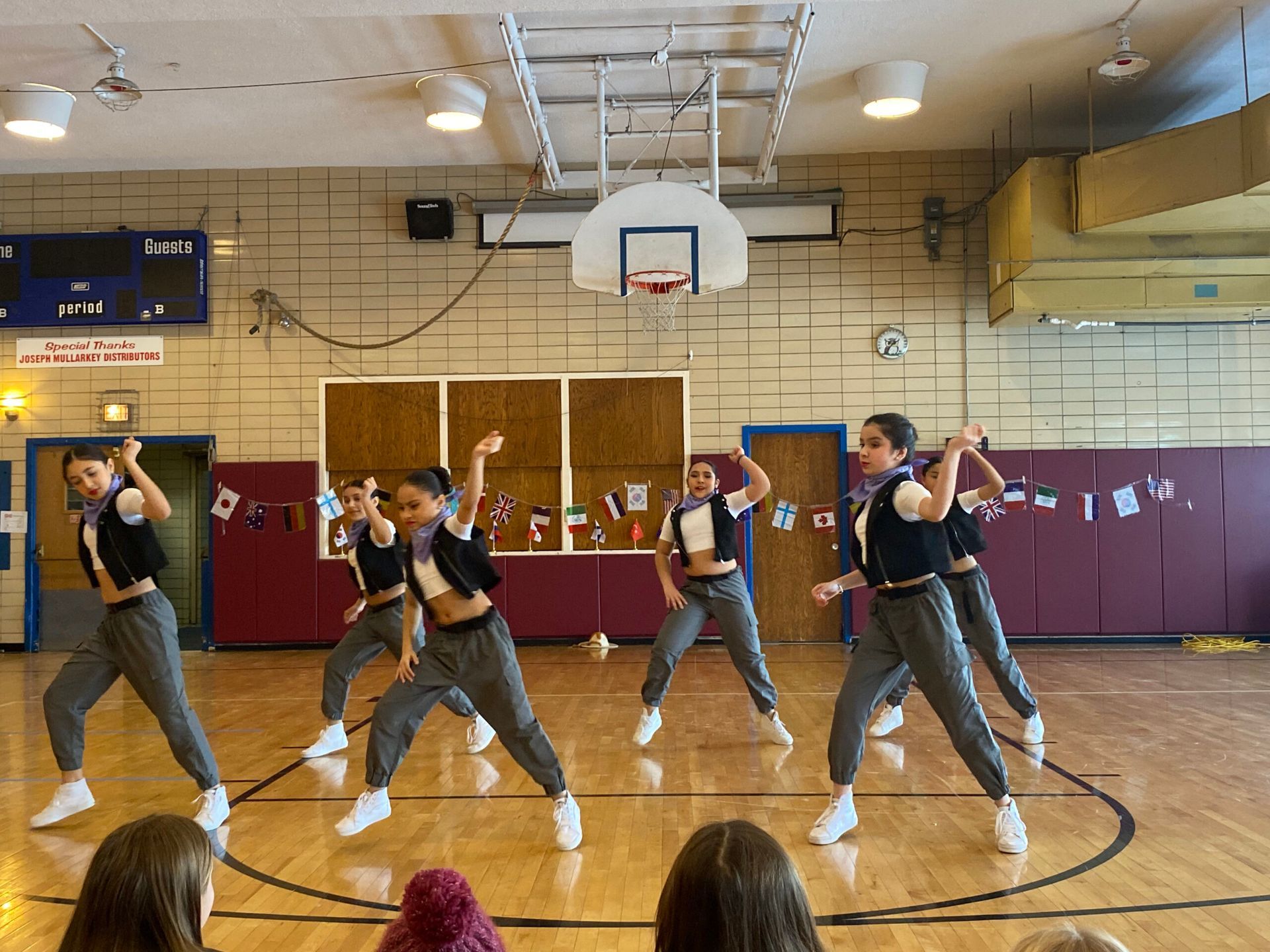 A group of young women are dancing in a gym.