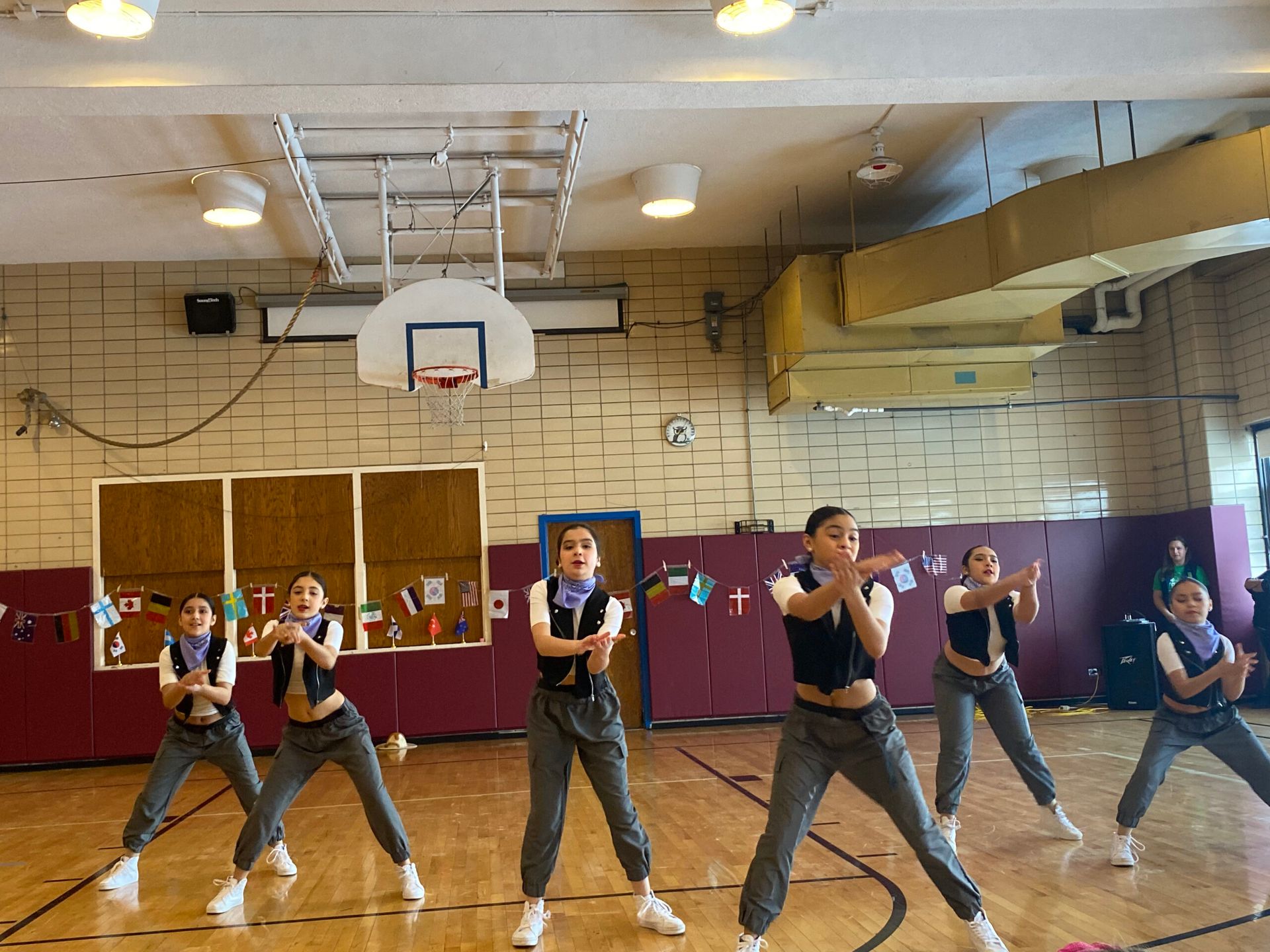 A group of young girls are dancing in a gym.