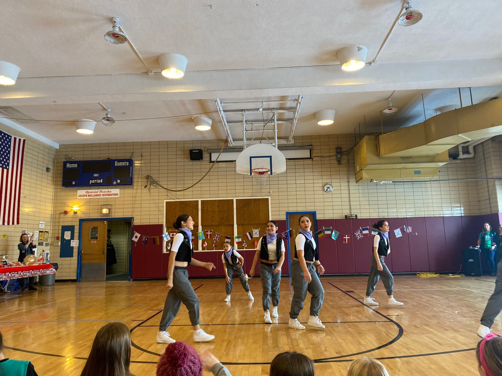 A group of people are dancing in a gym.