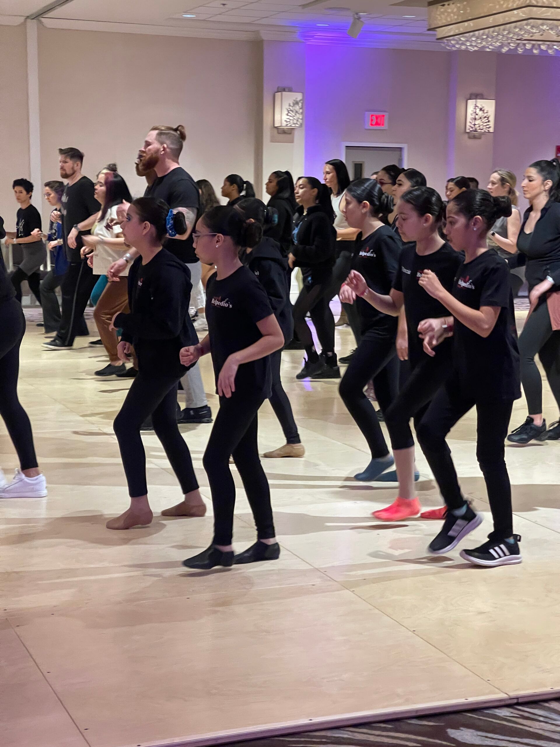 A group of people are dancing on a dance floor