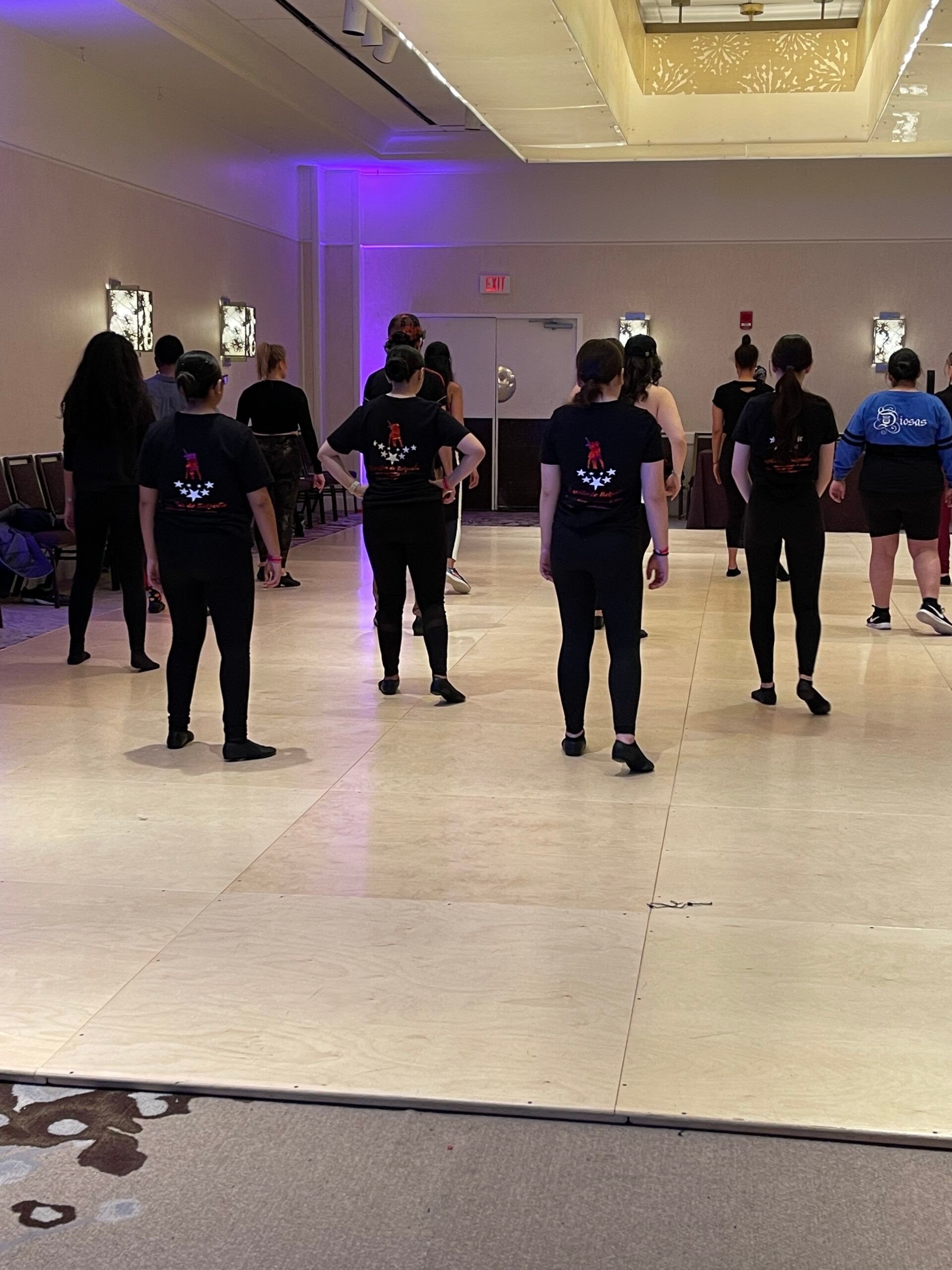 A group of people are standing on a dance floor.
