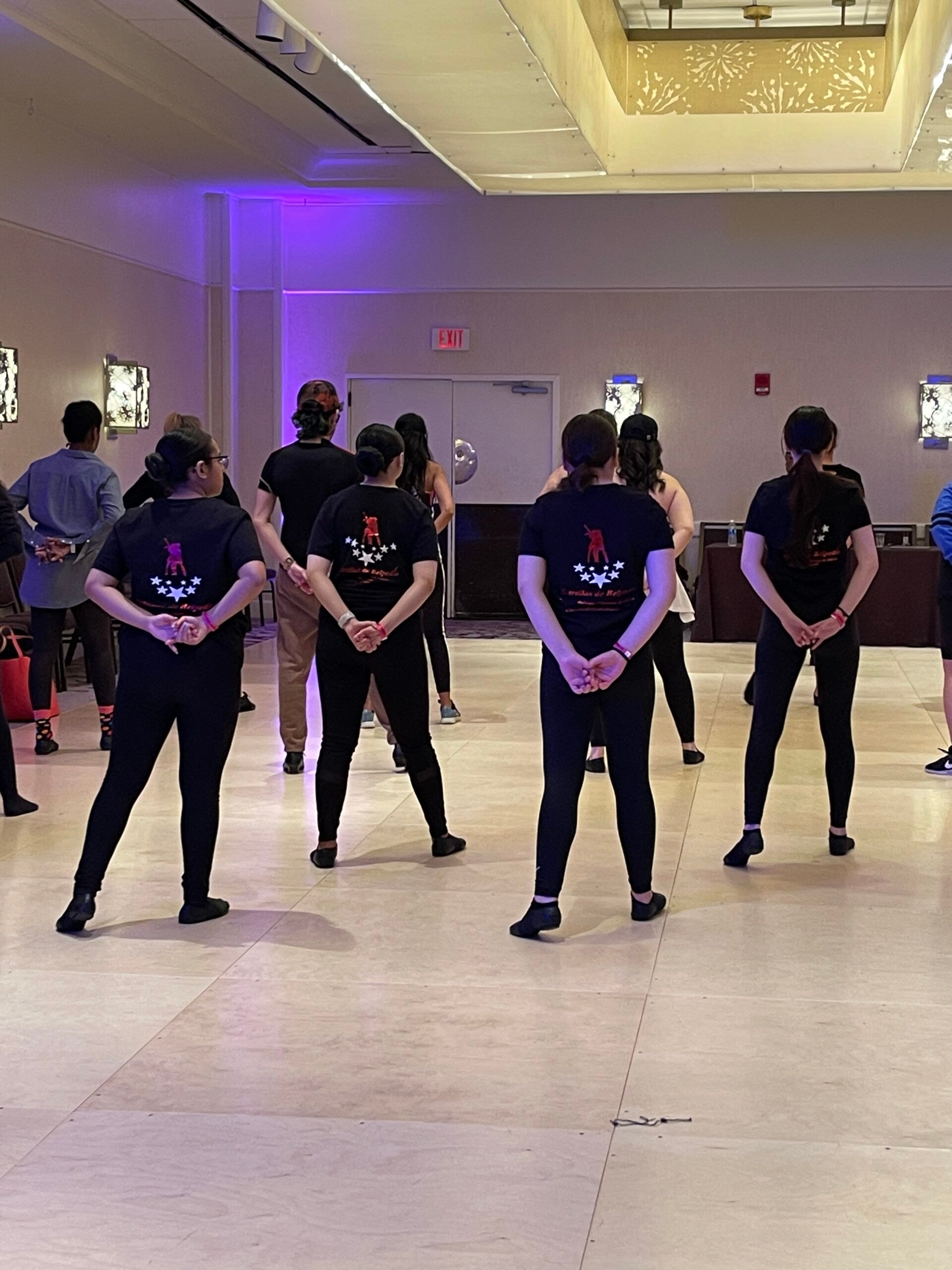 A group of people are standing in a room with their backs to the camera.
