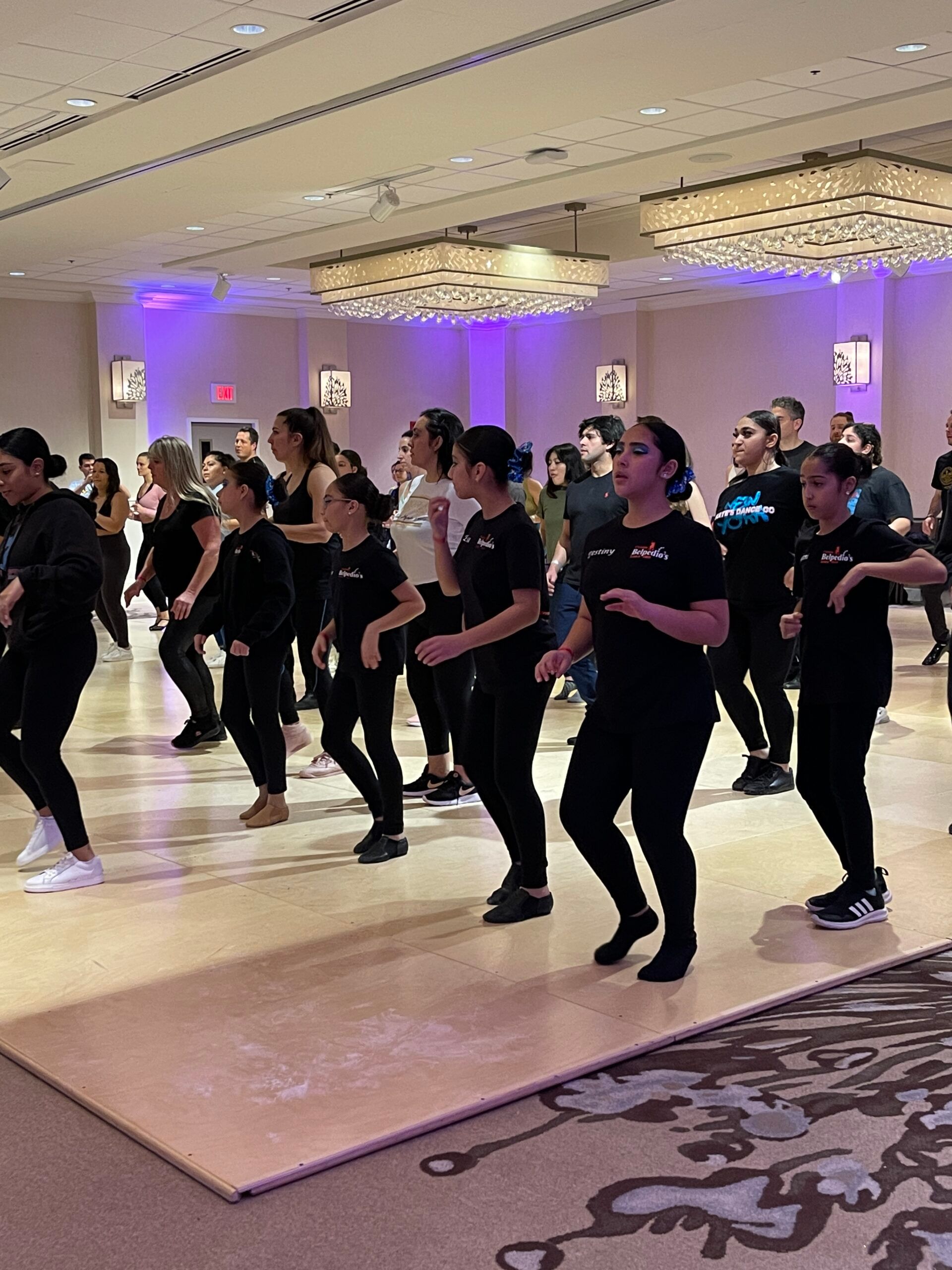 A group of people are dancing in a large room.