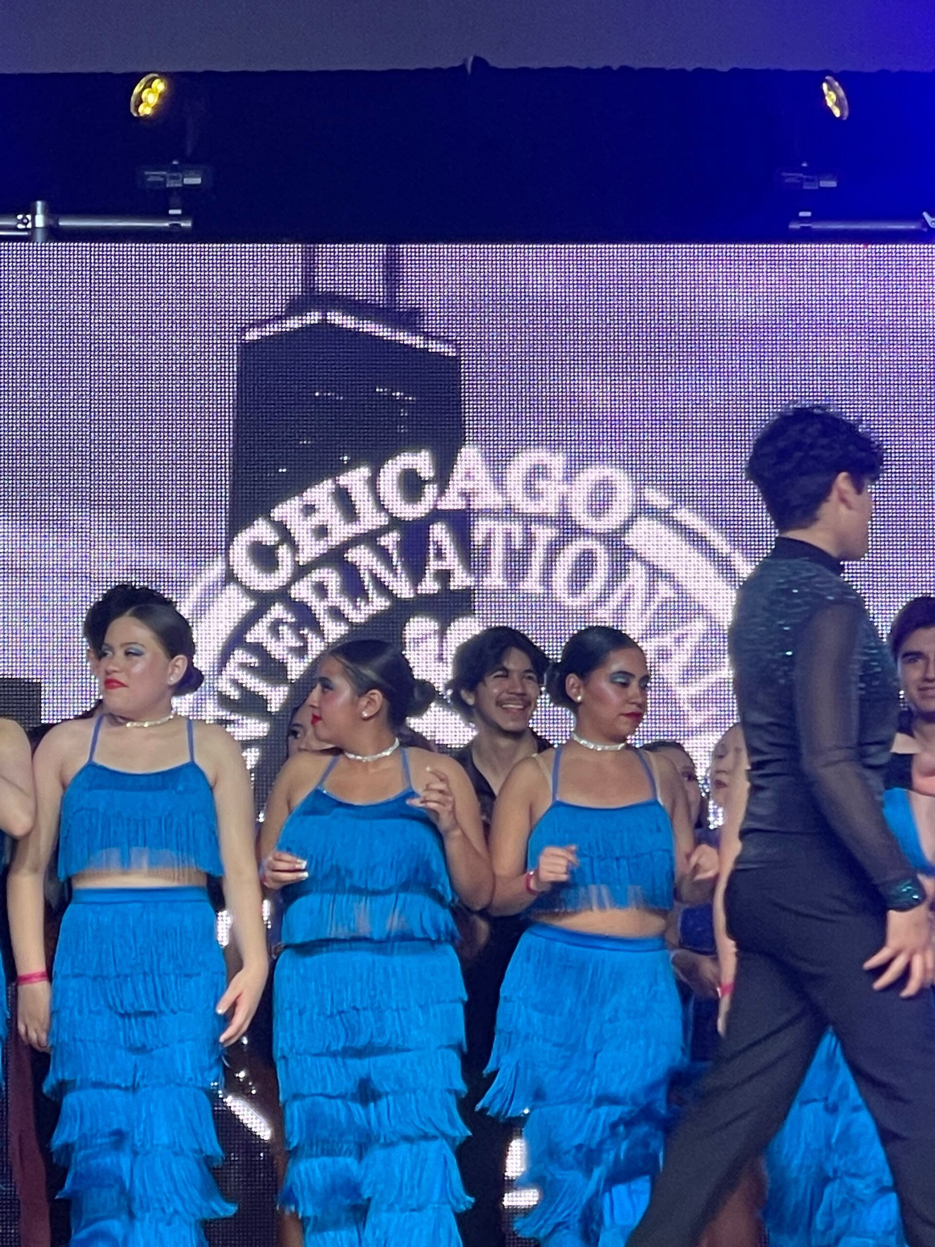 A group of people are dancing in front of a screen that says chicago international