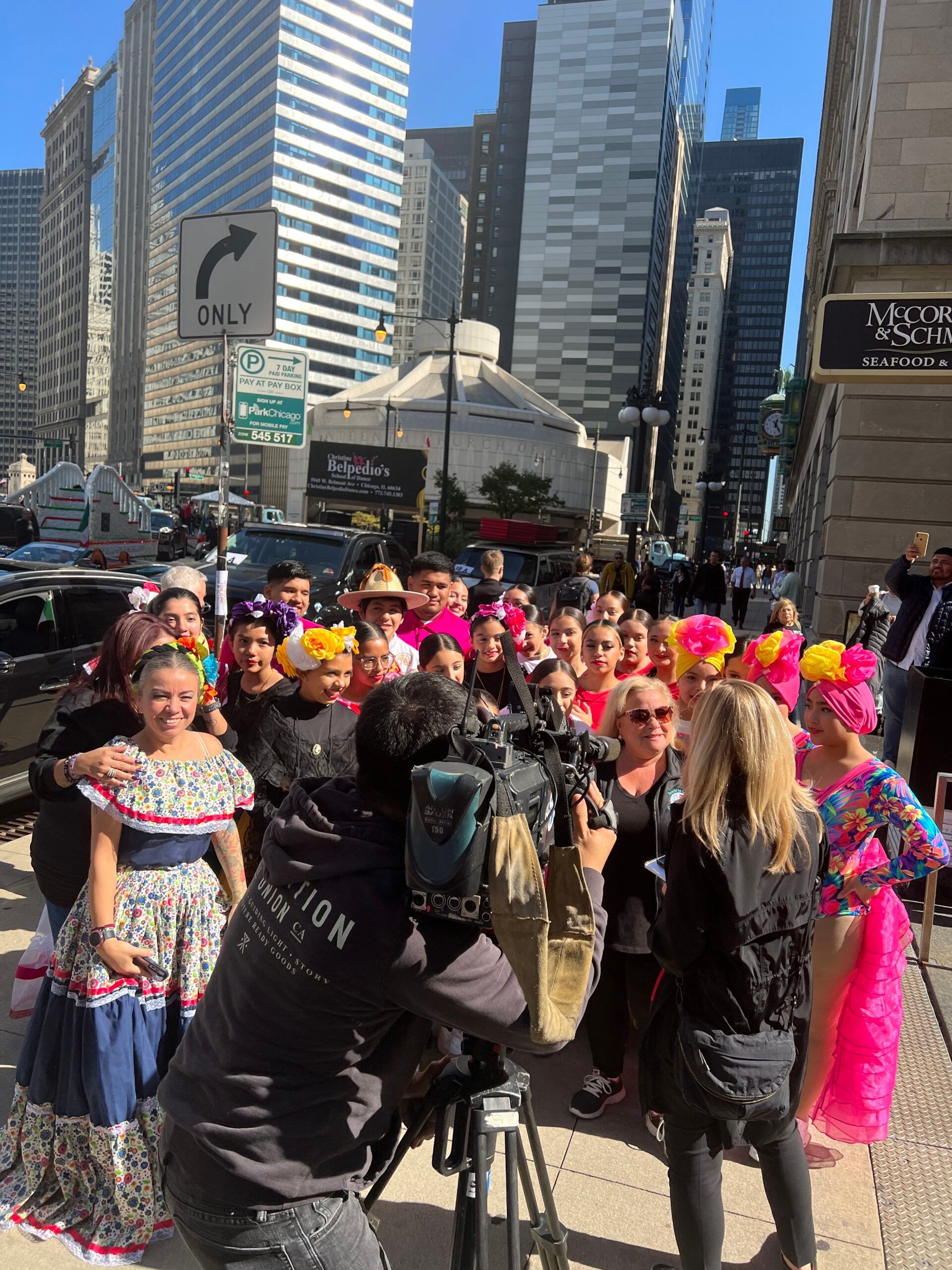 A group of people are standing in front of a sign that says one way