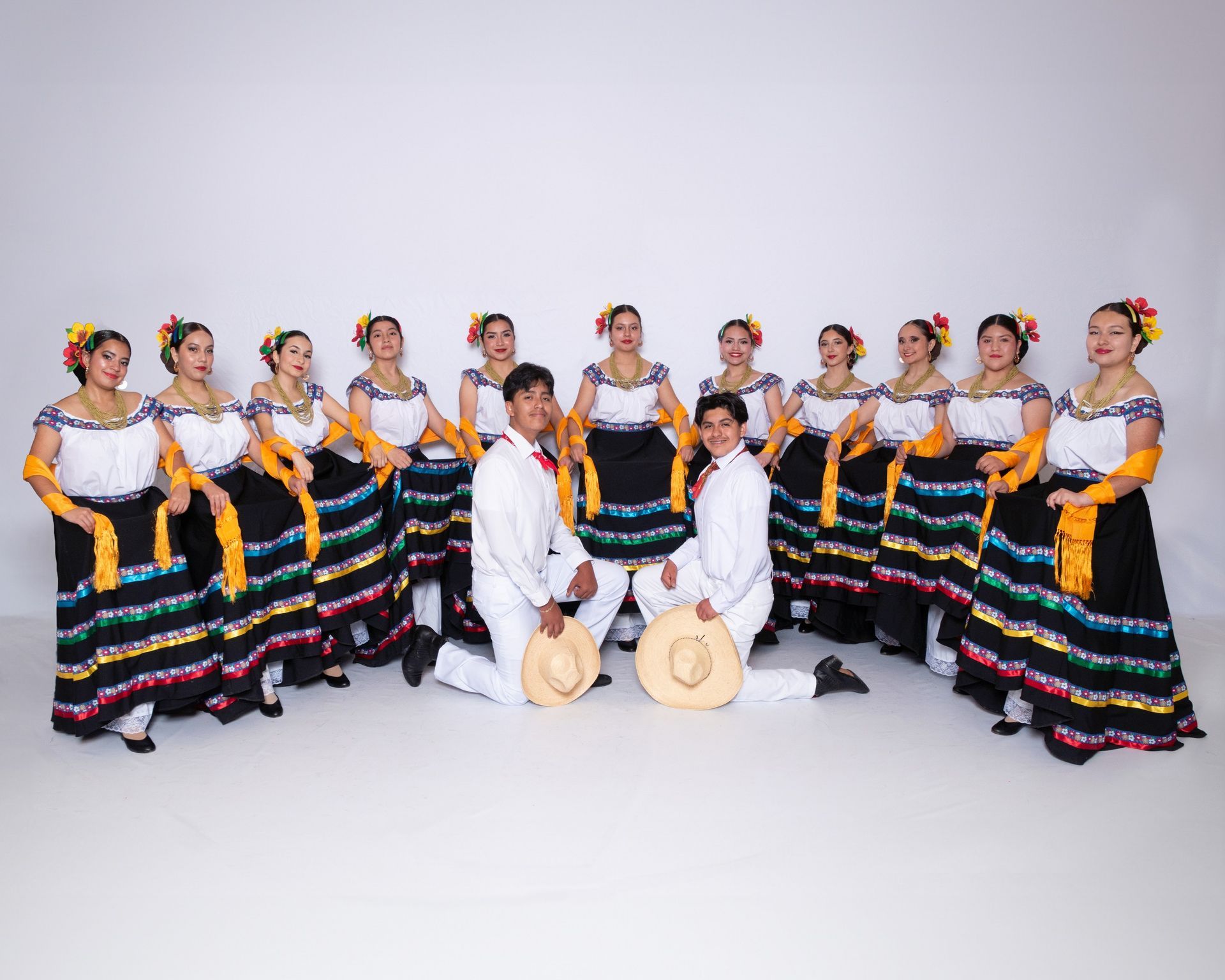 A group of people in traditional mexican costumes are posing for a picture.