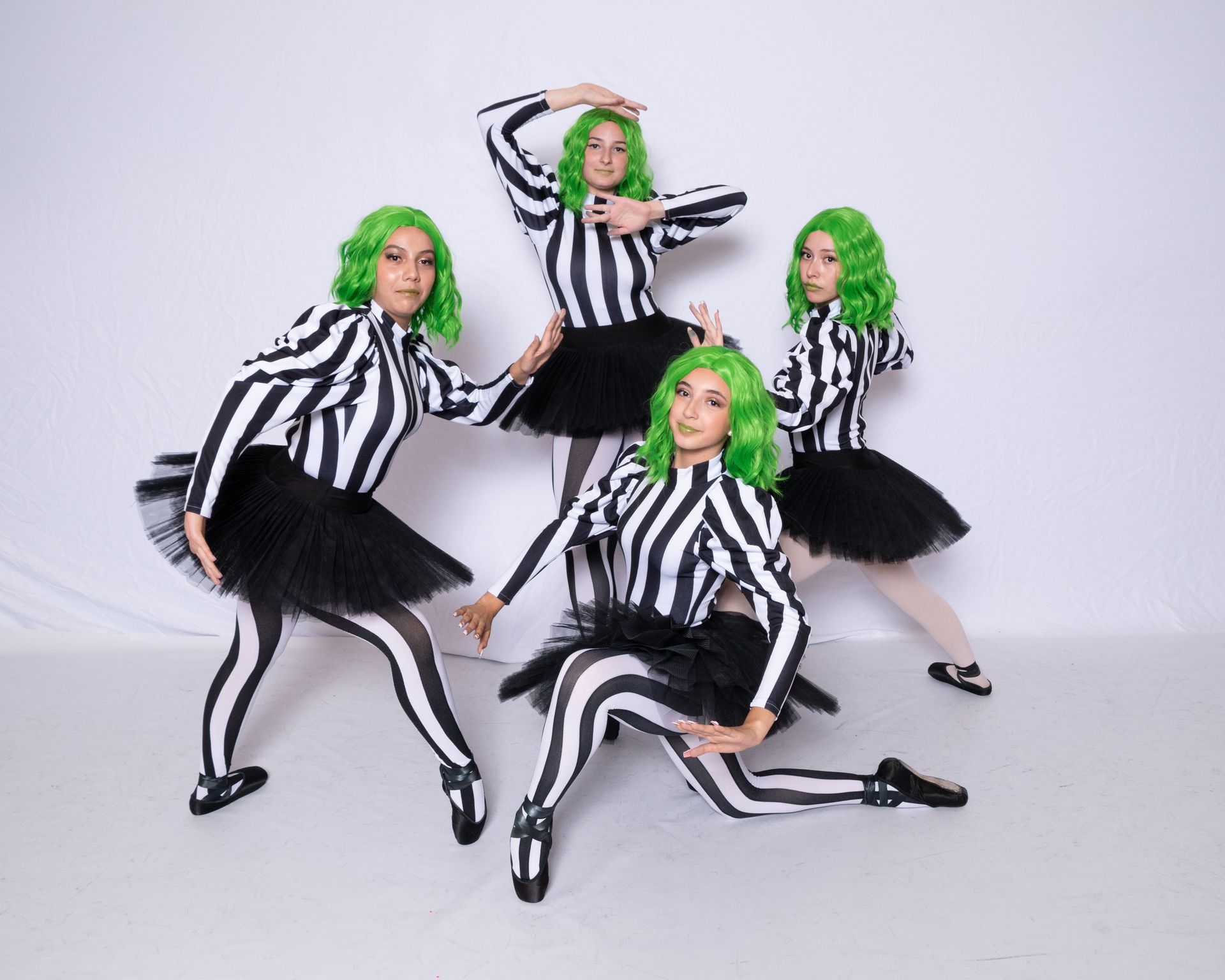 A group of women with green hair are posing for a picture