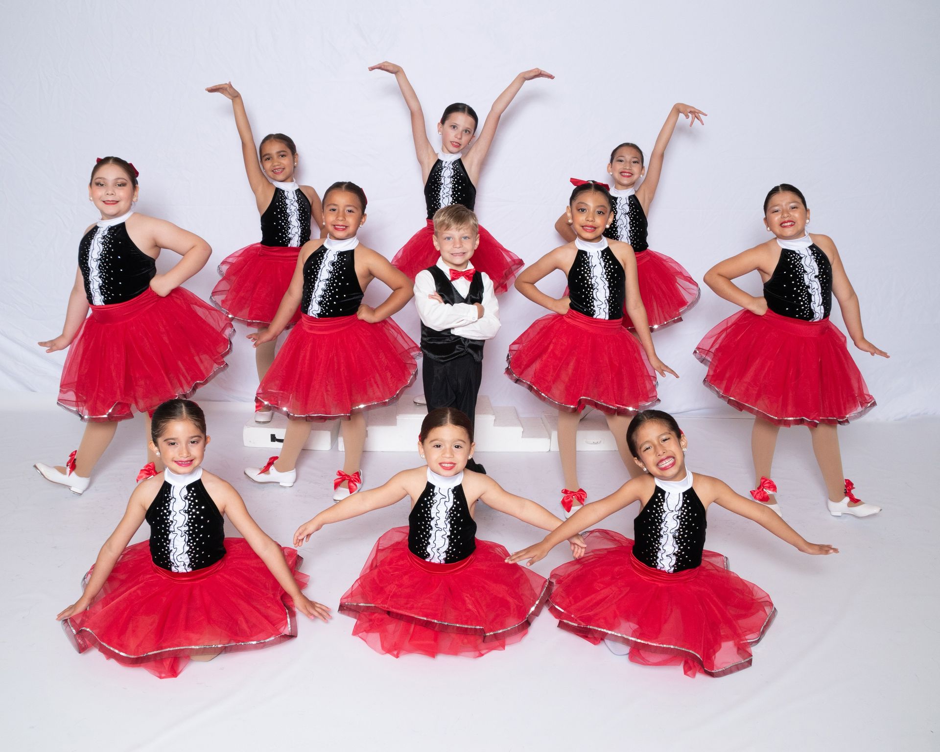 A group of young ballerinas are posing for a picture in a black and white photo.