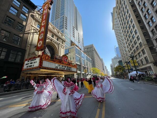 A parade is taking place in front of the chicago theater