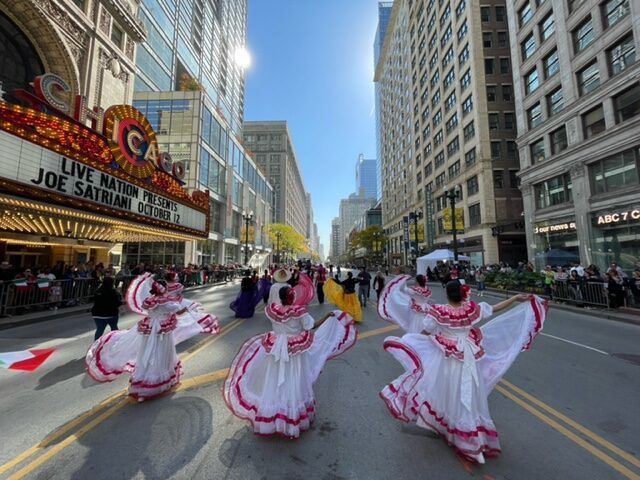 A group of people are dancing in front of a chicago theater
