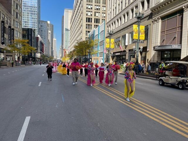 A group of people are marching down a city street.