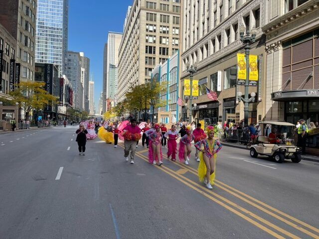 A group of people are marching down a city street.