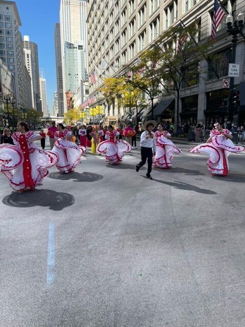 A group of people are dancing on a city street