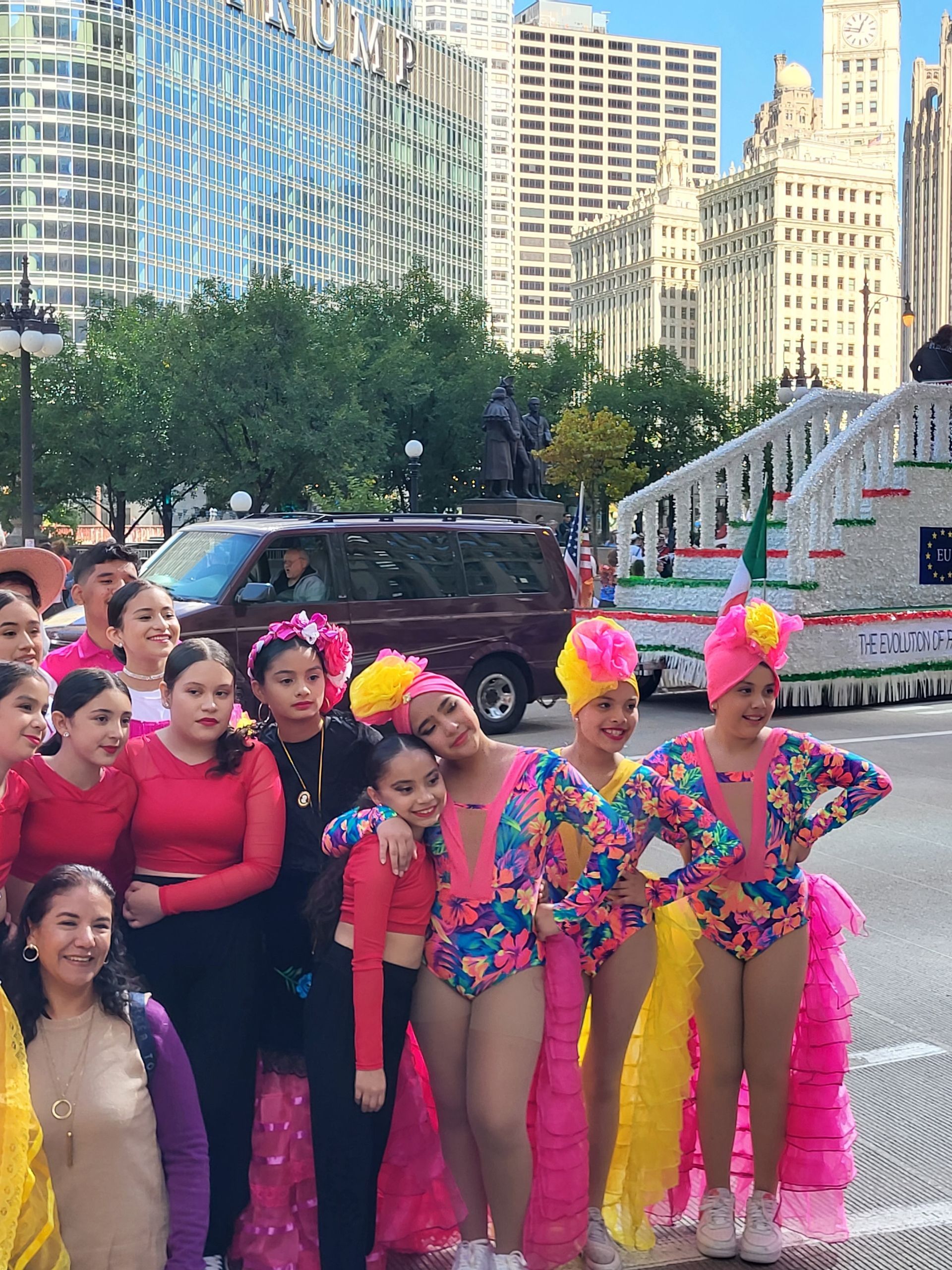 A group of young girls in colorful costumes are posing for a picture.