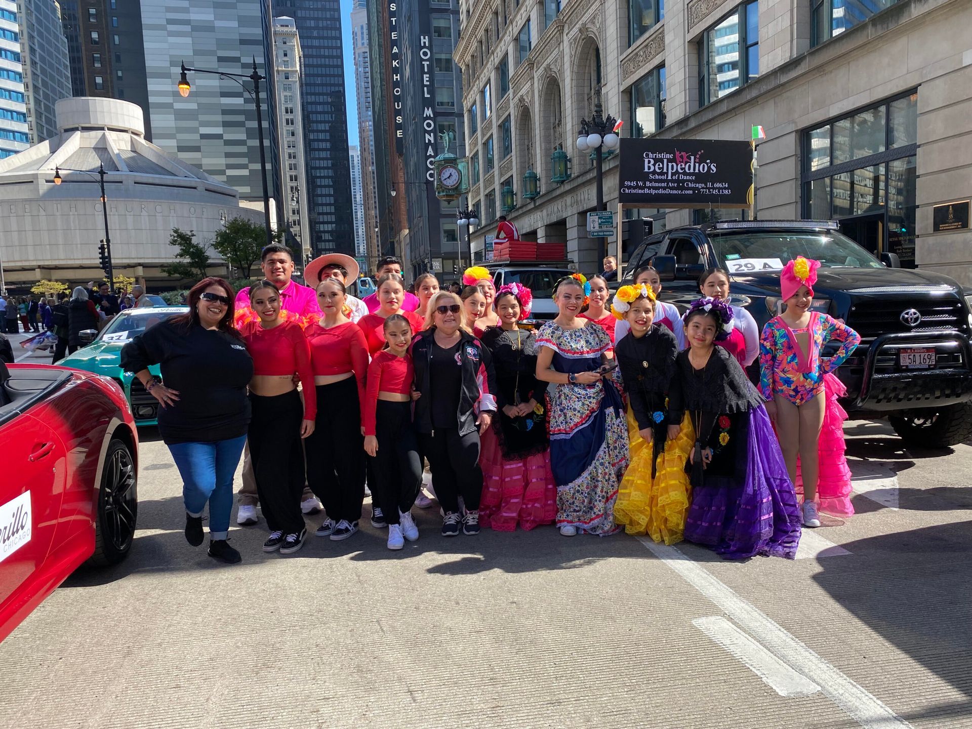 A group of people are posing for a picture on a city street.
