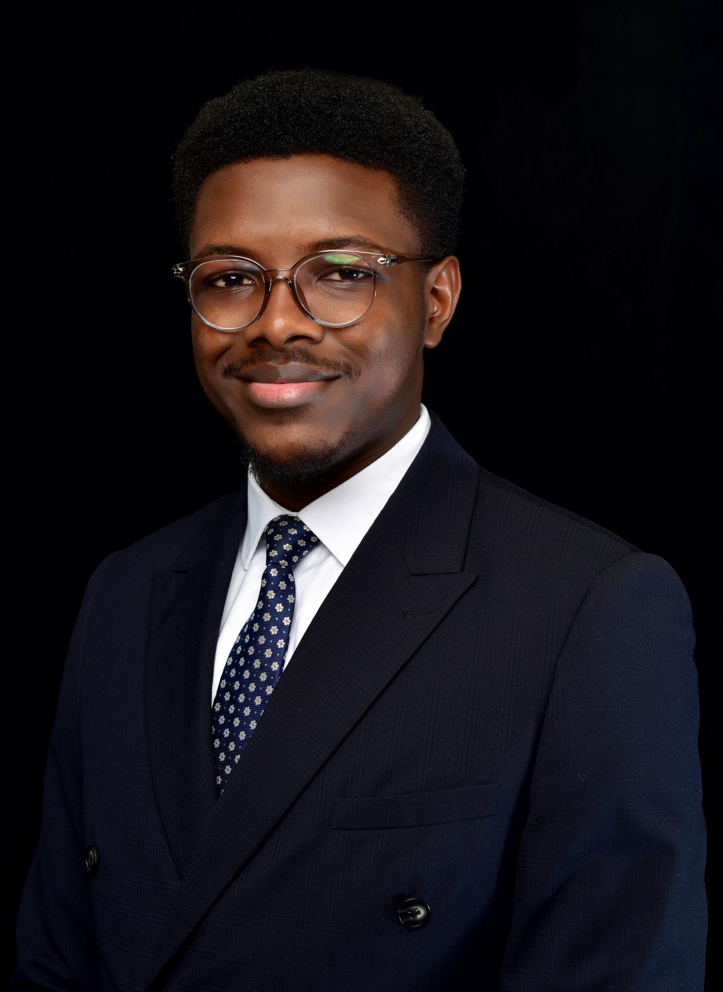 A young man in a suit and tie is smiling for the camera.