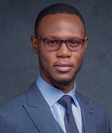 A man in a suit and tie is wearing glasses.