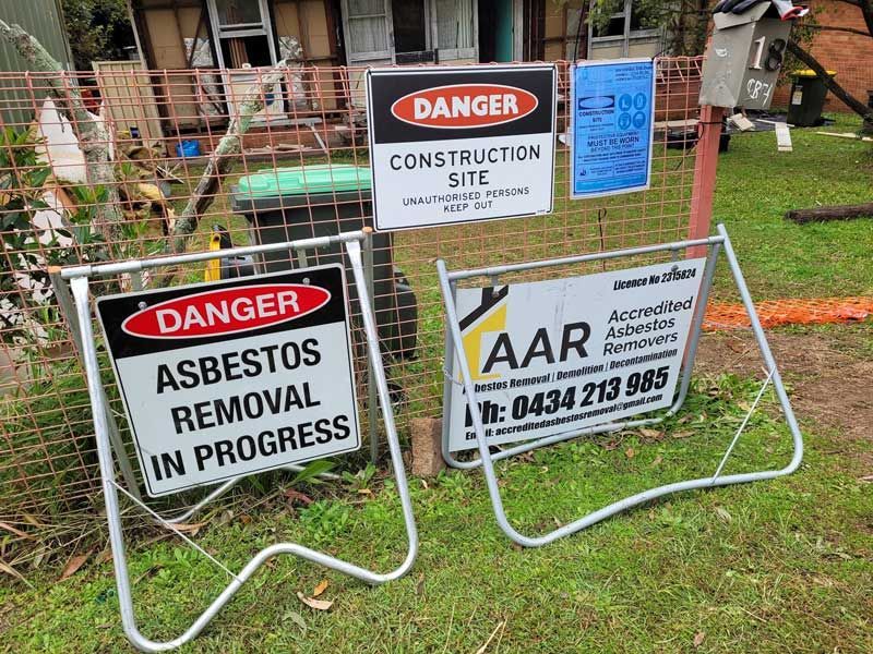 A Couple Of Signs That Say Danger Asbestos Removal In Progress — Accredited Asbestos Removers in Casino, NSW