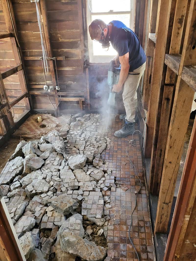 A Man Using A Hammer To Break Up The Concrete On The Floor — Accredited Asbestos Removers in Ballina, NSW