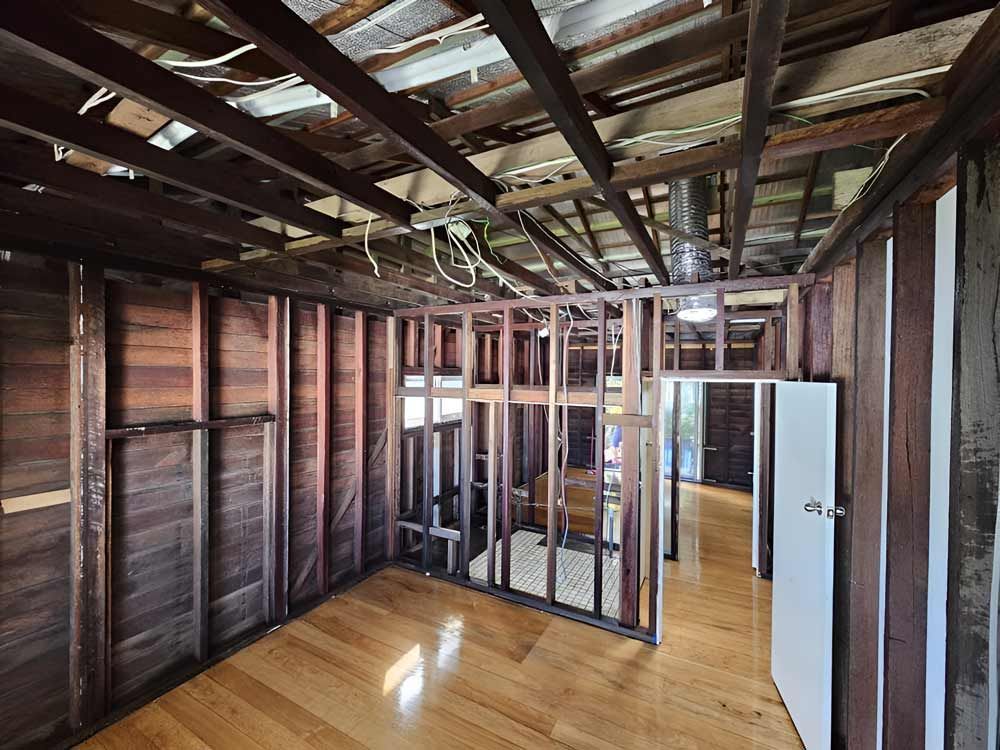 An Empty Room With Wooden Walls And A White Door Demolition — Accredited Asbestos Removers in Casino, NSW