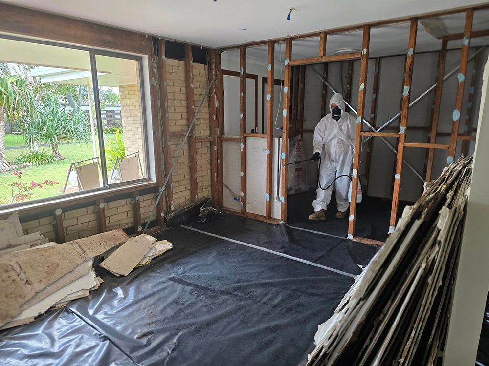 Room Undergoing Renovation; Person in Protective Suit Spraying — Accredited Asbestos Removers in Lismore, NSW