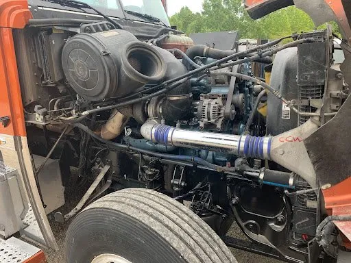 The engine of a semi truck is visible under the hood.