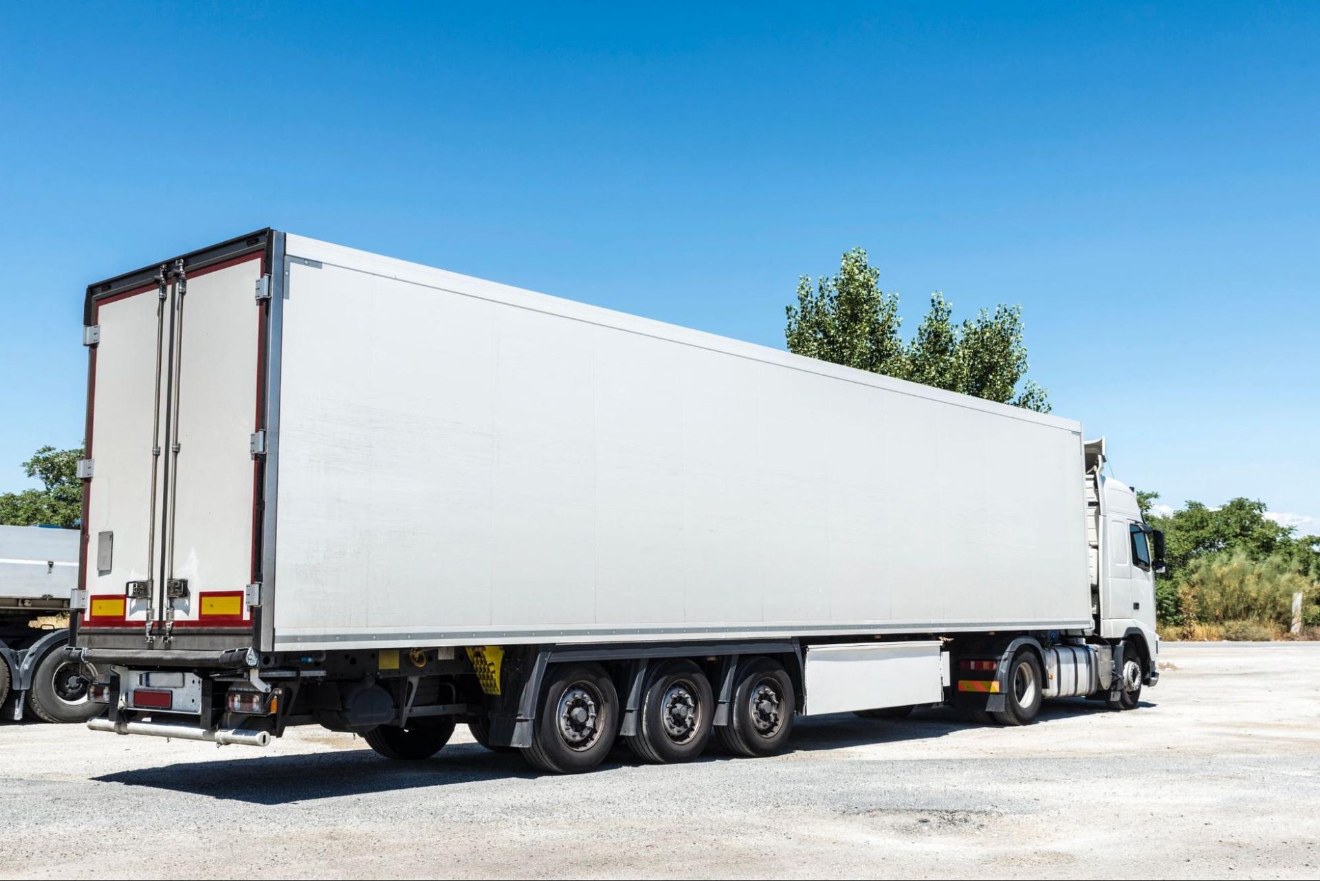 A white semi truck is parked in a parking lot.