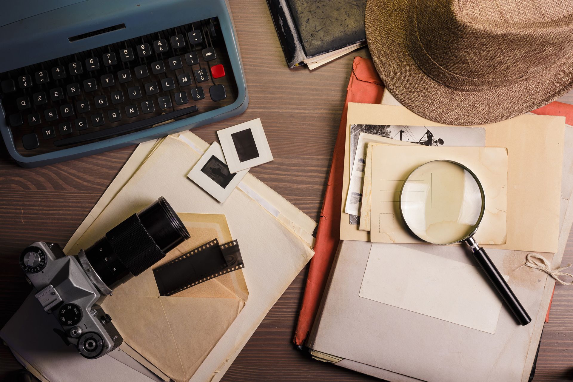 Private investigator desk with documents, a magnifying glass, and a camera. 