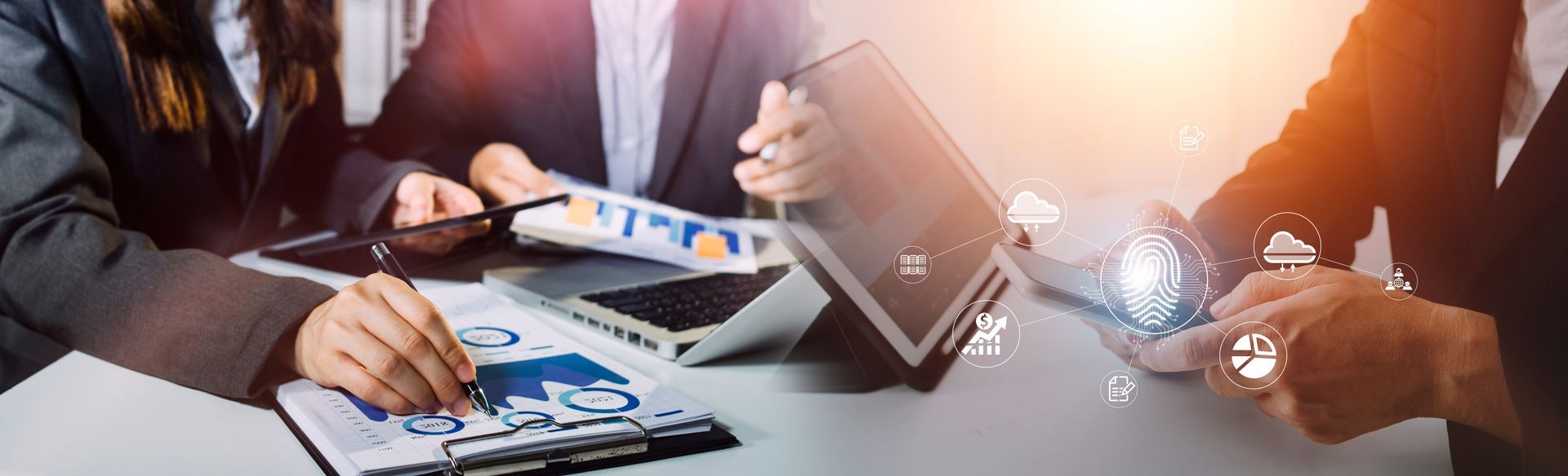 Business people at table with documents and devices, brainstorming, collaborative work.
