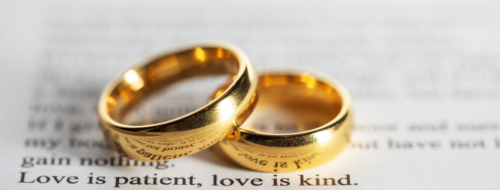 Gold wedding rings on book page symbolizing love, trust, and the importance of matrimonial background checks before marriage