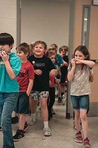 A group of children are walking down a hallway.