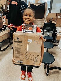 A young boy is holding a cardboard box with a toy in it.
