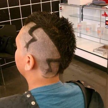 A man with a mohawk has the letter s painted on his head