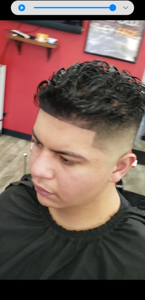 A man is getting his hair cut at a barber shop